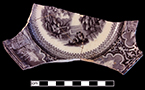 Refined white earthenware saucer printed underglaze in dark purple in romantic central pattern  and scene vignette border. Impressed mark “Improved Stone China” and printed mark of Chinese characters in purple luster. Lot: 18BC27/341.